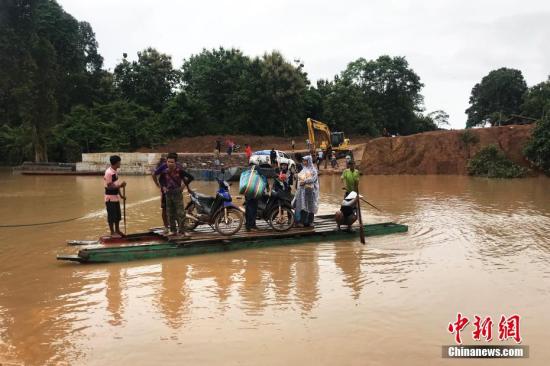 当地时间2018年7月25日，越南阿速坡省Sanamxai，色贡河水位上涨，民众使用简易木筏过河。