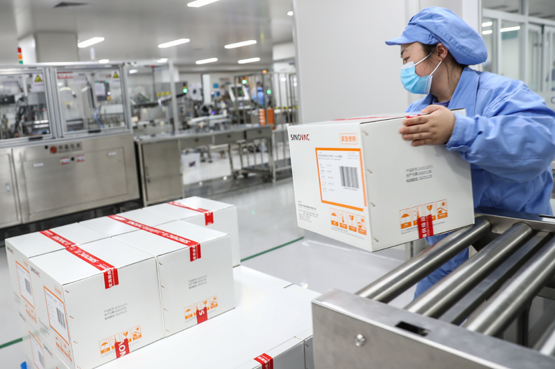 工作人员在科兴中维的新冠疫苗包装车间搬运新冠疫苗成品（图源：新华社）
